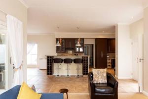 ein Wohnzimmer mit einem Sofa und einer Küche in der Unterkunft Trafford Cottage on Kingswood Golf Estate in George