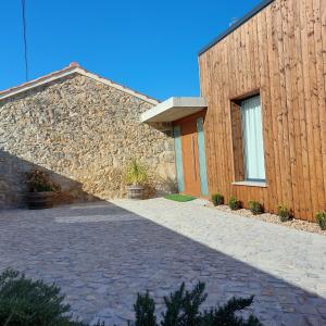 un bâtiment avec un mur en pierre et une allée en briques dans l'établissement Adega D'Aldeia, 