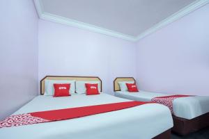 two beds in a room with red pillows at Apollo Hotel Johor Bharu in Johor Bahru