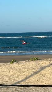 a plane flying over the ocean on a beach at Condomínio The Village Flecheiras in Flecheiras