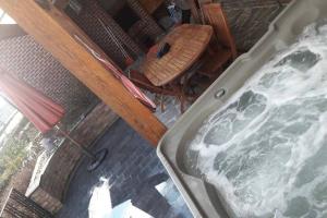 una vista aérea de una bañera, una mesa y una silla en Gîte Blanc Bleu Sauna et jacuzzi privatif borne de recharge, en Rochefort
