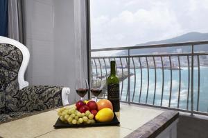 a table with a plate of fruit and two glasses of wine at Busan Beach Hotel Busan Songdo in Busan