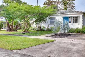 een wit huis met een blauwe deur en bomen bij Pet-Friendly South Miami Home with Private Pool! in Miami