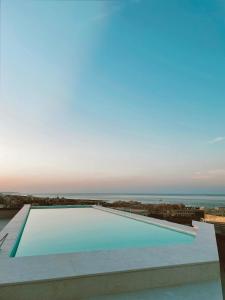 una piscina con vista sull'oceano sullo sfondo di SO City Hotel Adults Only a San Giuliano