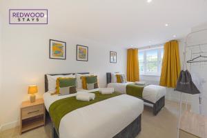 2 łóżka w pokoju z żółtymi zasłonami w obiekcie BRAND NEW Spacious 4 Bedroom Houses For Contractors & Families with FREE Parking, Garden, Fast Wifi and Netflix By REDWOOD STAYS w mieście Farnborough