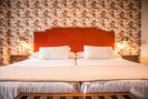 1 dormitorio con 1 cama grande y cabecero rojo en Hotel A Casa Do Rio, en Padrón