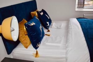 - un canapé blanc avec des oreillers bleus et jaunes dans l'établissement Beeston House 3 BR and FREE Parking, à Beeston