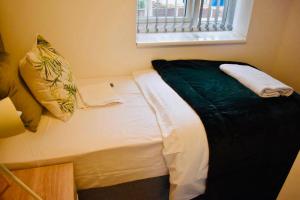 - un petit lit dans une chambre avec fenêtre dans l'établissement Beeston House 3 BR and FREE Parking, à Beeston
