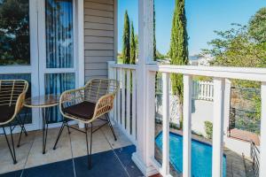 a porch with chairs and a table and a pool at Sidwell Gardens, Adjacent to Kingswood Estate in George