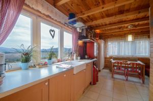 a kitchen with a sink and a large window at Domki na Polach Piwniczna-Zdrój in Piwniczna