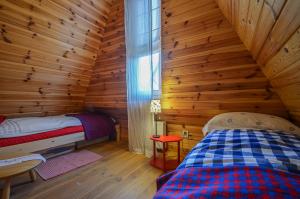 a bedroom with a bed in a log cabin at Domki na Polach Piwniczna-Zdrój in Piwniczna +56 photos
