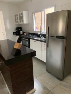 a kitchen with a stainless steel refrigerator and a counter at Apartamento Praia da Cal in Torres