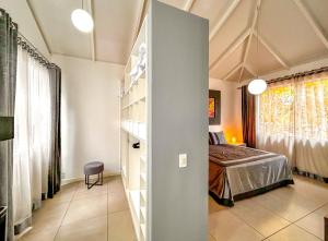 Villa Barriguda - Casa Anturio em Chapada Diamantina في بالميراس: غرفة نوم مع سرير ورف كتاب