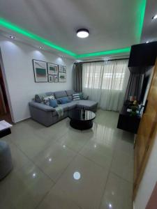 ein Wohnzimmer mit einem Sofa und grünem Licht in der Unterkunft Cómodo Apartamento en San Isidro in Mendoza