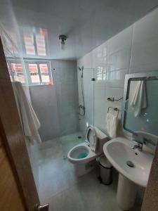 a white bathroom with a toilet and a sink at Cómodo Apartamento en San Isidro in Mendoza