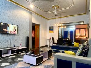 a living room with a blue couch and a table at Appartement hôte + in Ouagadougou