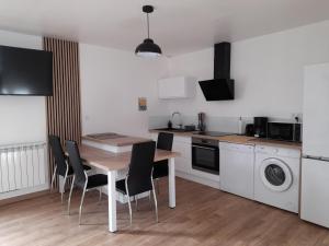 a kitchen with a table and chairs in a kitchen at Appartement T2, avec Terrasse. in La Roche-sur-Yon