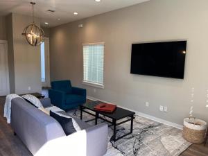 a living room with a couch and a tv on a wall at Charming House Downtown in Houston