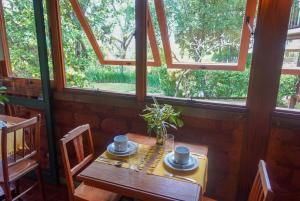 a wooden table in a room with a window at Pousada Canto Verde in Tiradentes
