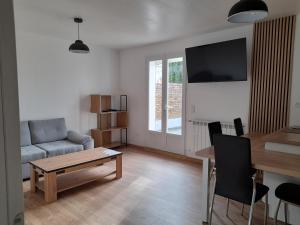 a living room with a couch and a table at Appartement T2, avec Terrasse. in La Roche-sur-Yon