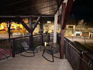 a patio with two chairs and a candle on a table at Ambra Room's in Braşov