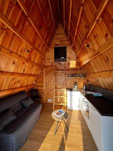 a living room with a couch in a wooden cabin at Tiny House Ardennes in Fromelennes