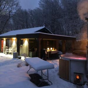 Cabaña cubierta de nieve con bañera de hidromasaje en la nieve en Au Bien-Etre à Deux, en Spa