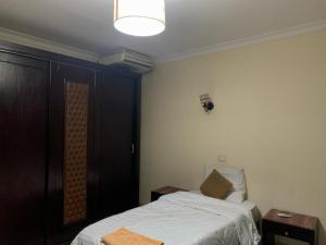Sheraton apart-hotel في القاهرة: غرفة نوم بسرير وطاولتين ومصباح