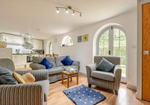 a living room with a couch and two chairs at Vine Cottage in West Runton