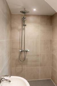 a shower in a bathroom with a sink at Emerald Lodge in Puddletown