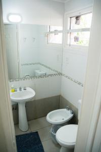 a bathroom with two toilets and a sink and a mirror at Alma Mendoza Hotel in Mendoza