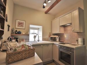 een keuken met witte kasten, een wastafel en een aanrecht bij 1 Bed in Whorlton G0121 