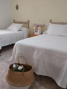 een kamer met 2 bedden en een mand op de vloer bij ALOJAMIENTO TURISTICO LAS SOLANERAS in Solana del Pino