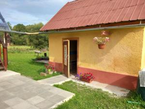 une petite maison avec un pot de fleurs sur la porte dans l'établissement Guest House SAMSON, à Vahaneč