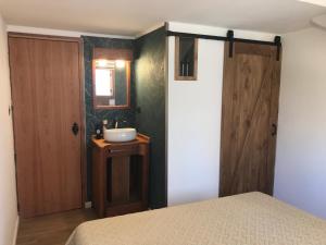 1 dormitorio con cama, lavabo y puerta en Antigua Viña Bed and Breakfast, en Viña del Mar