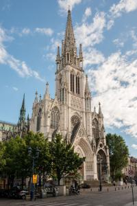 a large cathedral with a steeple on a cloudy sky at Vue sur le Palais - Nancy Gare Congrès - PARKING - T3 in Nancy