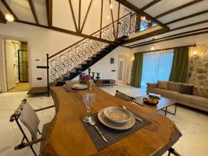 uma sala de estar com uma mesa de madeira e uma escada em Villa Mustafa em Fethiye