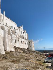 a building on top of a hill with cars parked at Casa Vico Melles in Ostuni