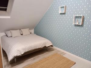 una camera con un letto con una parete blu di La Salicorne, maison d'hôtes. a Brévands
