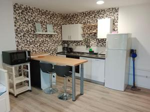 a kitchen with a wooden table and a refrigerator at La Salicorne, maison d'hôtes. in Brévands +27 photos