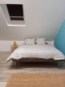 a bed in a white room with a bed sidx sidx sidx at La Salicorne, maison d'hôtes. in Brévands