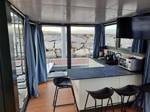 uma cozinha com um balcão e bancos em frente às janelas em Floating Experience Black Pearl, Lago Maggiore em Dormelletto