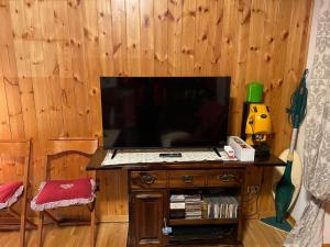 a flat screen tv sitting on top of a wooden wall at Appartamento Abetone Vacanze in Abetone +10 photos