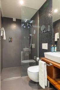 La salle de bains est pourvue de toilettes, d'un lavabo et d'une douche. dans l'établissement Casa do Ofício - Livreiro, à Porto