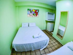 um quarto com uma cama branca numa sala verde em Pousada Litoral em Porto de Galinhas