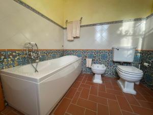 a bathroom with a tub and a toilet and a sink at Art Apartment Agriturismo il Vecchio Merlo in Larciano