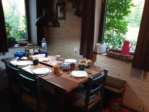 - une table en bois avec des chaises et des assiettes dans l'établissement MAGIC MOUNTAIN, à Žabljak