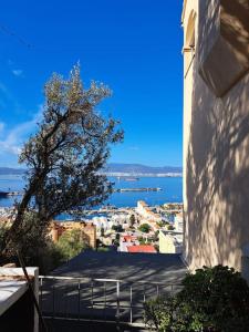 a view of a city from a building with a tree at Sea View Apartment with Balcony & Beautiful Views in Gibraltar