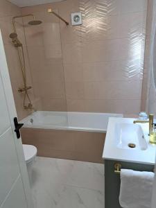 a bathroom with a sink and a tub and a toilet at Sea View Apartment with Balcony & Beautiful Views in Gibraltar