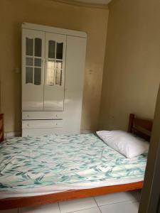 ein Schlafzimmer mit einem großen Bett und einem Schrank in der Unterkunft Casa Edgar in Manaus